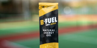 A packet of Scottish Bee B-Gel is held up against a blurred out field in the background.