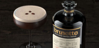 A bottle of Brunette Coffee Liqueur stands next to an Espresso Martini cocktail serve with coffee beans between the two.