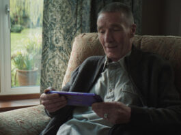 Cadbury displays generous nature in new campaign An elderly man sits in a chair by a window holding a large Cadbury Dairy Milk tablet bar.