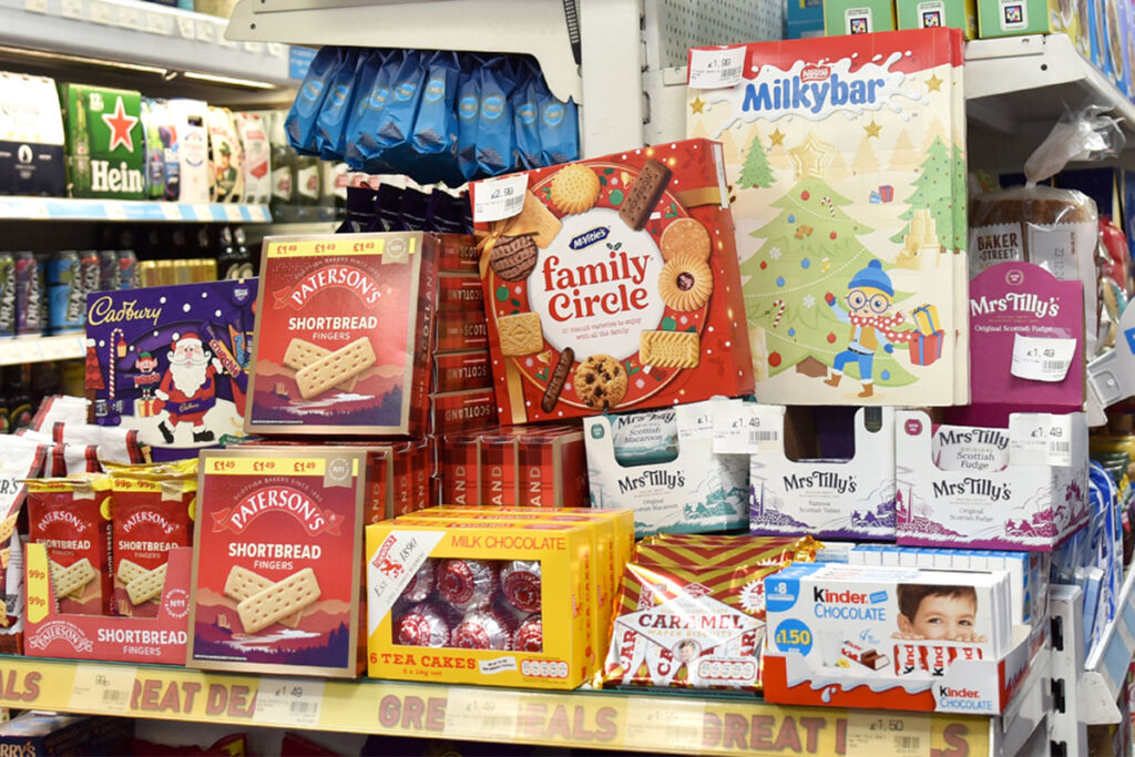 A selection of biscuits and chocolates on promotion in a store during the Christmas period.