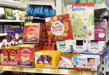 A selection of biscuits and chocolates on promotion in a store during the Christmas period.