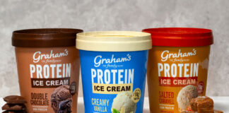 Packs of Graham's Protein Ice Creams sit on a countertop including Double Chocolate, Creamy Vanilla and Salted Caramel variants, with pieces of chocolate next to the Double Chocolate; vanilla pods next to the Creamy Vanilla; and pieces of caramel next to the Salted Caramel.