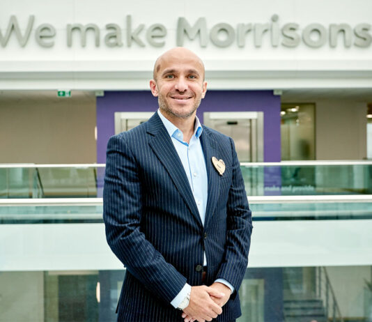 Morrisons boss takes presidential role at GroceryAid Rami Baitiéh, chief executive of Morrisons, stands in front of a sign that reads 'We make Morrisons' as he is appointed president of GroceryAid.