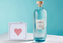 A bottle of Isle of Harris Love Gin stands next to a card with a love heart on it.