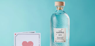 A bottle of Isle of Harris Love Gin stands next to a card with a love heart on it.