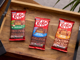 KitKat invites consumers to Share in a break Packs of KitKat sharing bars sit on a wooden tray including KitKat Hazelnut, KitKat Double Chocolate and KitKat Salted Caramel.