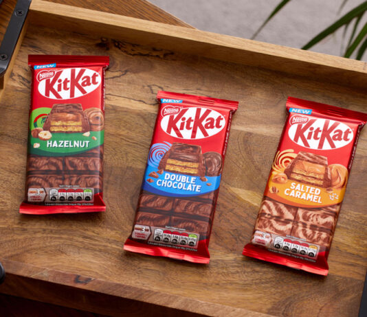 KitKat invites consumers to Share in a break Packs of KitKat sharing bars sit on a wooden tray including KitKat Hazelnut, KitKat Double Chocolate and KitKat Salted Caramel.