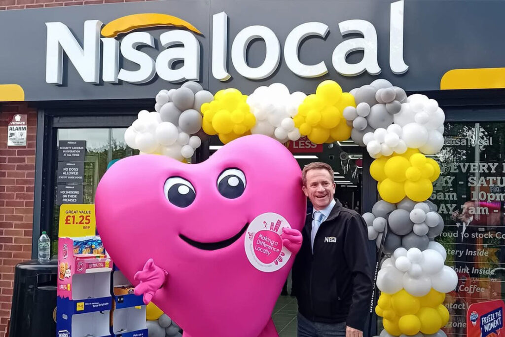 Nisa's Making a Difference Locally mascot Maddie stands outside of Nisa Local store during a store opening event.