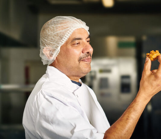 Punjab Pakora launches Square Sausage Pakora for Burns A chef holds a piece of Punjab Pakora Square Sausage Pakora in his hand looking at it.