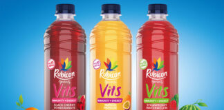 Bottles of Rubicon Spring Vits stand against a blue background with illustrations of fruit around the bottles.