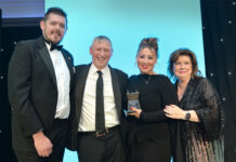 Tom Pook of Hovis, Dennis Williams and Sophi Williams of Premier Broadway Convenience store and actress Elaine C Smith stand on a stage at the Scottish Grocer Awards for the Community Store of the Year award win.