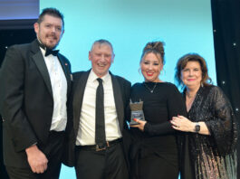 Awards Profile – Community Retailer of the Year Tom Pook of Hovis, Dennis Williams and Sophi Williams of Premier Broadway Convenience store and actress Elaine C Smith stand on a stage at the Scottish Grocer Awards for the Community Store of the Year award win.
