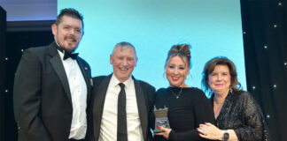 Tom Pook of Hovis, Dennis Williams and Sophi Williams of Premier Broadway Convenience store and actress Elaine C Smith stand on a stage at the Scottish Grocer Awards for the Community Store of the Year award win.