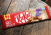 A multipack of KitKat Nescafé Mocha Flavour biscuits sit on a wooden table.