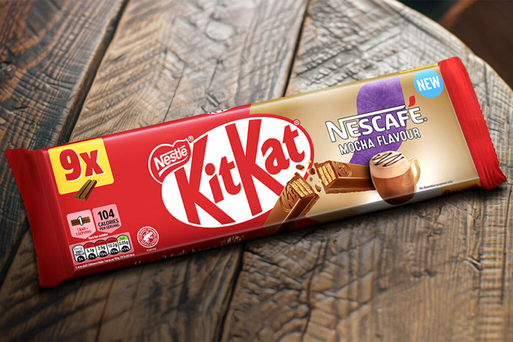 A multipack of KitKat Nescafé Mocha Flavour biscuits sit on a wooden table.