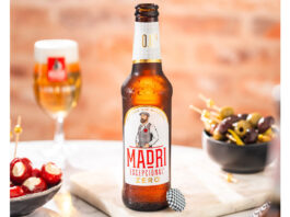 Madrà Excepcional launches Zero alcohol beer A bottle of Madrà Excepcional Zero stands on a table with a bowl of olives to the right and a bowl of cheese stuffed tomatoes to the left with a Madrà Excepcional branded glass behind the bottle.
