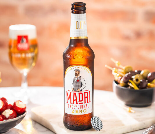 Madrí Excepcional launches Zero alcohol beer A bottle of Madrí Excepcional Zero stands on a table with a bowl of olives to the right and a bowl of cheese stuffed tomatoes to the left with a Madrí Excepcional branded glass behind the bottle.