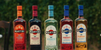 A line-up of Martini vermouth bottles stand on a marble table. (From left to right) Martini Fiero L'Aperitivo, Rosso Vermouth, Bianco Vermouth, Vibrante L'Aperitivo Vibrante Non-Alcoholic and Floreale L'Aperitivo Non-Alcoholic.