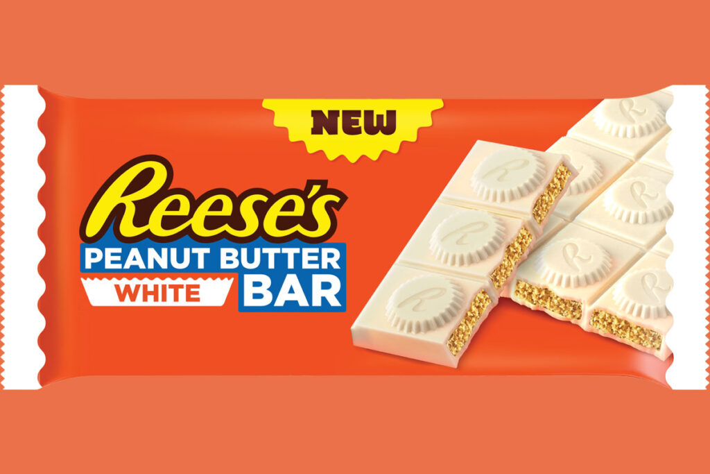 A pack shot of Reese's Peanut Butter White bar against an orange background.