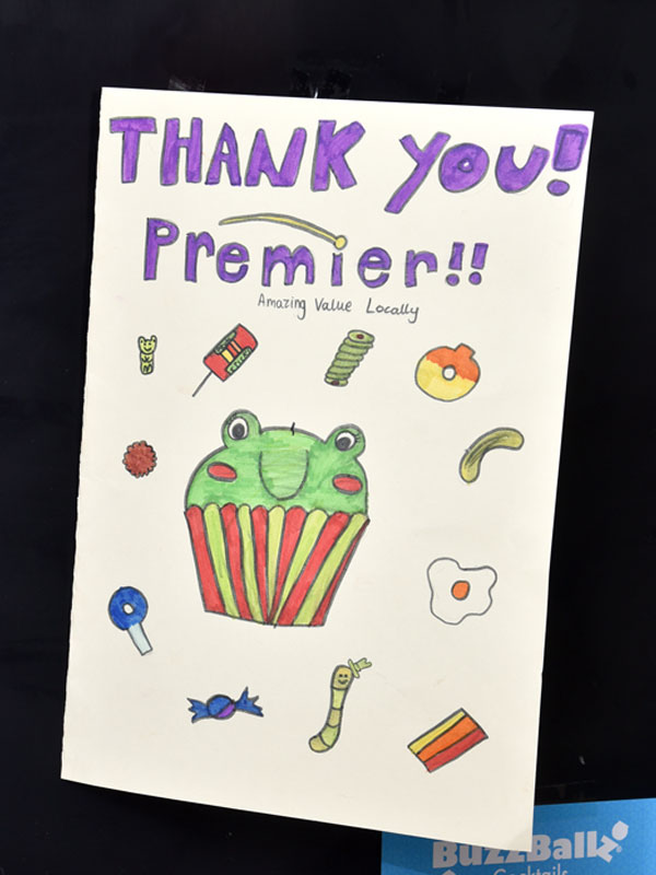 A 'Thank You Premier' card for members of staff at Premier Broadway Convenience Store with hand-drawn pictures of sweets and a cupcake on the front.