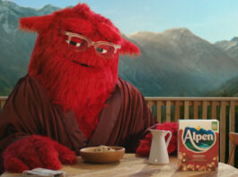 New Alpen mascot campaign to target adult consumers Alpen's mascot 'Mother' sits at a breakfast table with a box of Alpen, a jug for milk and a bowl of muesli in front of her. Mother is a large, red and furry character who wears glasses.
