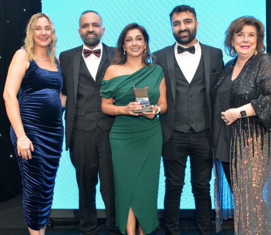 Awards Profile – The Innovation Award Laura McDiarmid, Vikas Sud, Shamly Sud, Guna Sud and Elaine C Smith all stand on the Scottish Grocer Awards 2024 stage whilst Shamly holds a trophy for The Innovation Award 2024.
