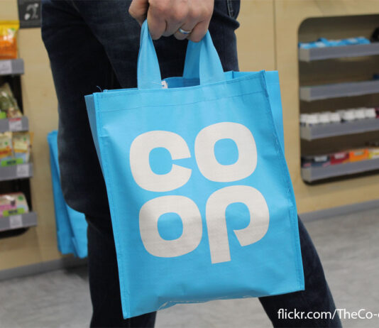 Co-op admits breach of Competitions Authority A person carries a blue Co-op Tote bag in a Co-op store with a photograph credit in the bottom right corner.