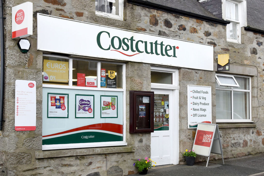 The front entrance of a Costcutter store featuring signage for the symbol group as well as signage for the Post Office.