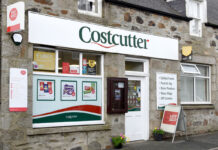 The front entrance of a Costcutter store featuring signage for the symbol group as well as signage for the Post Office.