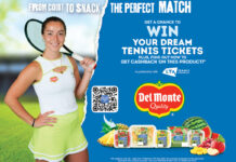 Jodie Burrage poses holding a tennis rackets against a tennis court background with a blue colour breaking into this with a torn paper effect for a Del Monte branded competition, the text. reads "From Court to Snack The Perfect Match Get a Chance to Win Your Dream Tennis Tickets Plus, Find out how to get cashback on this product" with the LTA logo, a QR code for the competition and the Del Monte logo along with an array of Del Monte fresh fruit packs as well as fresh fruit sitting around these packs.