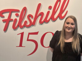 Filshill bolsters sales team with new hire Estelle Balfour, regional development manager at JW Filshill, stands in front of the Filshill 150 logo on a white wall.