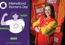 Natalie Lightfoot, store owner at Londis Solo Convenience Baillieston, stands wearing a Cheez-It branded jacket with an advert for the brand behind her with a picture of the post for International Women's Day 2025.