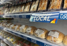 A chiller with sandwiches and rolls with strip runners along the shelving with the SGF Go Local branding across it, the text reads 'We Support Local'.