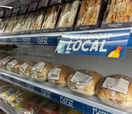 A chiller with sandwiches and rolls with strip runners along the shelving with the SGF Go Local branding across it, the text reads 'We Support Local'.