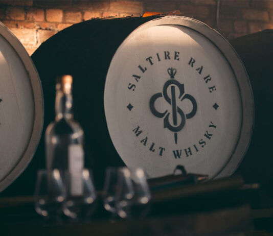 Saltire whisky spreads out around the world A whisky cask with the Saltire Rare Malt Whisky brand on the top of the lid with a bottle of whisky and nosing glasses in the foreground of the image.