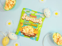Swizzels refreshes Squashies Easter sweets A packet of Swizzels Squashies Drumchick sits on a blue table with baskets filled with the sweets around the packet with small toy eggs around the packet.