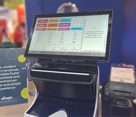 Allwyn showcases new National Lottery terminal at NCS The National Lottery Wave Terminal stands on a desk with an information card to its right and a ticket printer to its left.