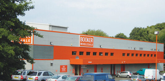 Booker drives festive sales with new Christmas guide Exterior image of Booker Longstone depot in Edinburgh with cars in the car park.