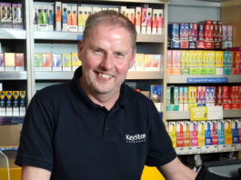 JW Filshill urges retailers to prepare for disposable vape ban Chris Cobb, store owner of KeyStore Cults in Aberdeen, stands at the till with a vaping gantry behind him.