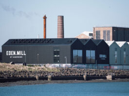 Production kicks off at Eden Mill distillery A photograph of the Eden Mill Distillery in St Andrews looking over a body of water to the distillery and its warehouses.