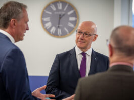 First Minister visits Highland Spring’s Blackford site First Minister of Scotland John Swinney stands talking to two men at the Highland Spring Group's Blackford site in Perthshire.