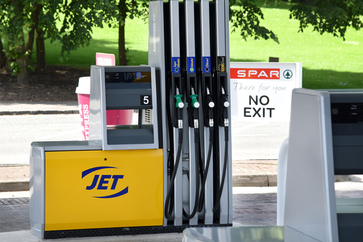Fuel pumps at a Jet branded forecourt garage with a Spar branded sign in the background warning of no exit.
