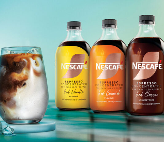 Nescafé has unveiled a trio of Espresso Concentrated coffee drinks Bottles of Nescafé Espresso Concentrated bottles are lined up against a blue background with a water design on the floor including Iced Vanilla, Iced Caramel and Iced Classic variants with a glass filled with milk and a shot of the concentrated coffee and ice.