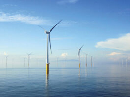 Scotmid secures 10 year green energy deal A range of wind turbines across a stretch of the sea.