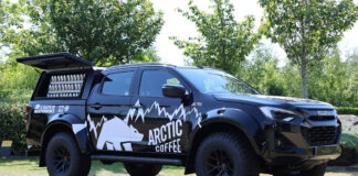An Arctic Coffee branded Izuzu D-Max Arctic Truck is parked with its side window open with bottles of the chilled coffee available for sale.
