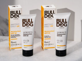 Packs of Bulldog Anytime Daily UV Moisturiser SPF 50 and Bulldog Anytime Daily UV Moisturiser SPF 30 with the tubes of cream standing outside the outer packs on a white table with their shadows casted onto a white wall behind the products.