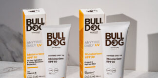 Packs of Bulldog Anytime Daily UV Moisturiser SPF 50 and Bulldog Anytime Daily UV Moisturiser SPF 30 with the tubes of cream standing outside the outer packs on a white table with their shadows casted onto a white wall behind the products.