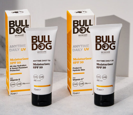 Bulldog Skincare launches 50 SPF UV Moisturiser Packs of Bulldog Anytime Daily UV Moisturiser SPF 50 and Bulldog Anytime Daily UV Moisturiser SPF 30 with the tubes of cream standing outside the outer packs on a white table with their shadows casted onto a white wall behind the products.