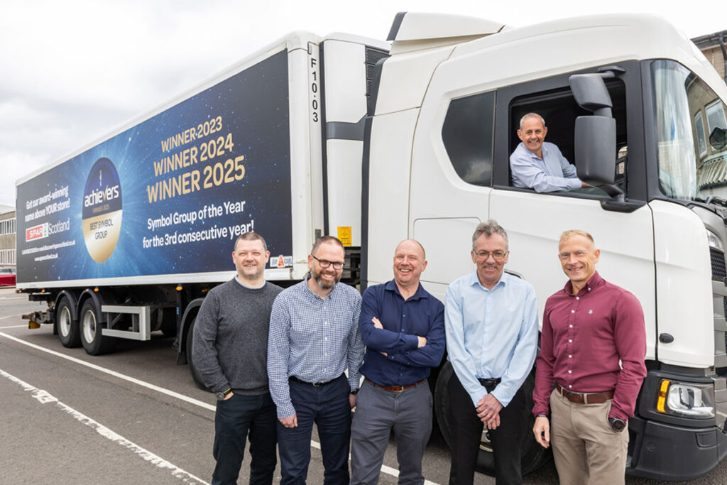 A group of people stand in front of a Spar Scotland lorry with the new livery highlighting its winning streak at the Scottish Wholesale Association's Achievers Awards with its three Symbol Group of the Year wins.