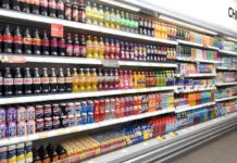 A range of soft drinks sitting in chillers in a store.